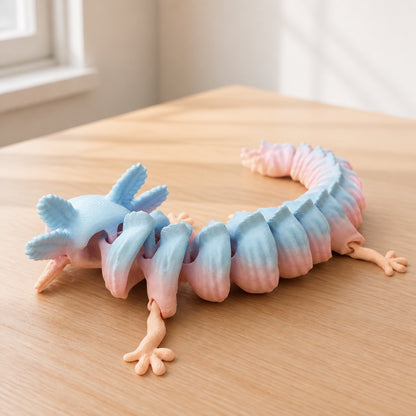 Pastel articulated axolotl displayed on a light oak desk