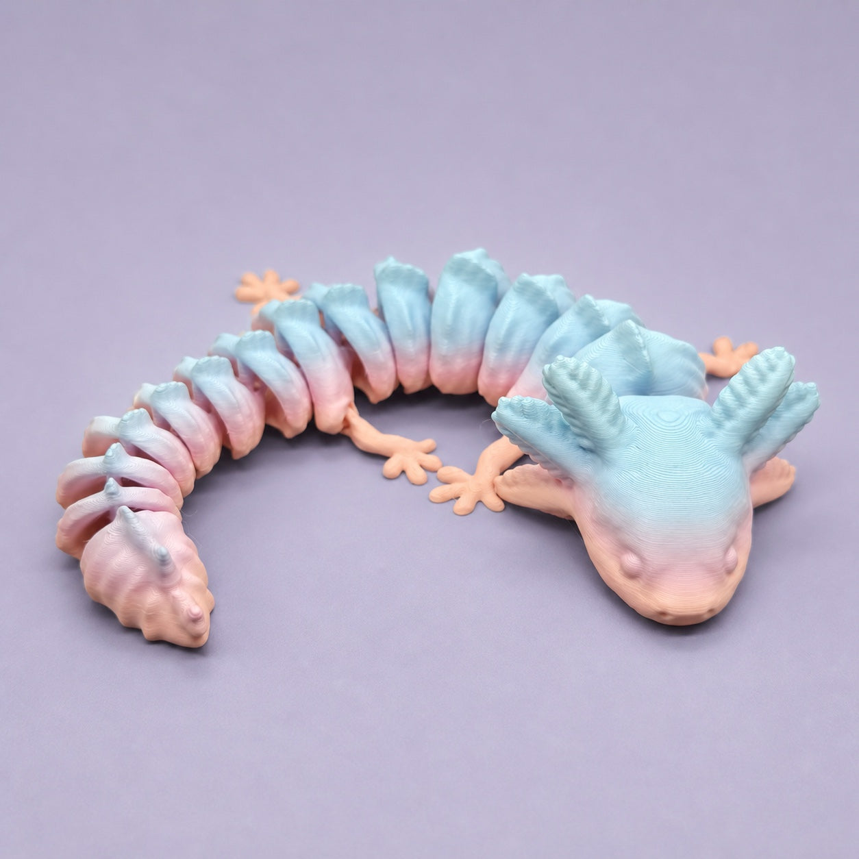 Curled pastel articulated axolotl showing its linked body segments