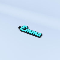 Emma personalised name keyring in Pacifico font with turquoise raised text on a black base.