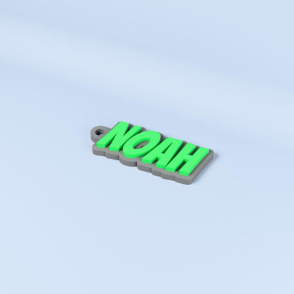 Noah personalised name keyring in Bangers font with green raised text on a dark gray base.
