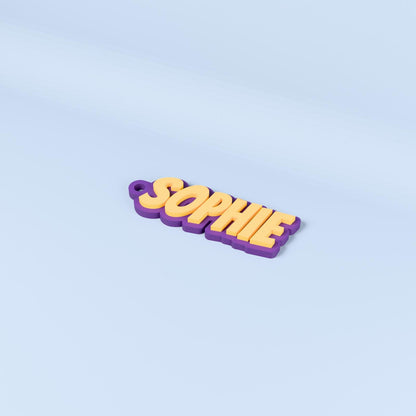 Sophie personalised name keyring in Bangers font with yellow raised text on an indigo purple base.