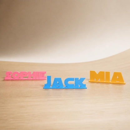 Sophie, Jack and Mia geometric space personalised PLA nameplates arranged in a warm neutral studio setting.