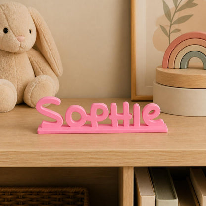 Sophie cartoon style personalised nameplate displayed on a warm neutral nursery shelf.