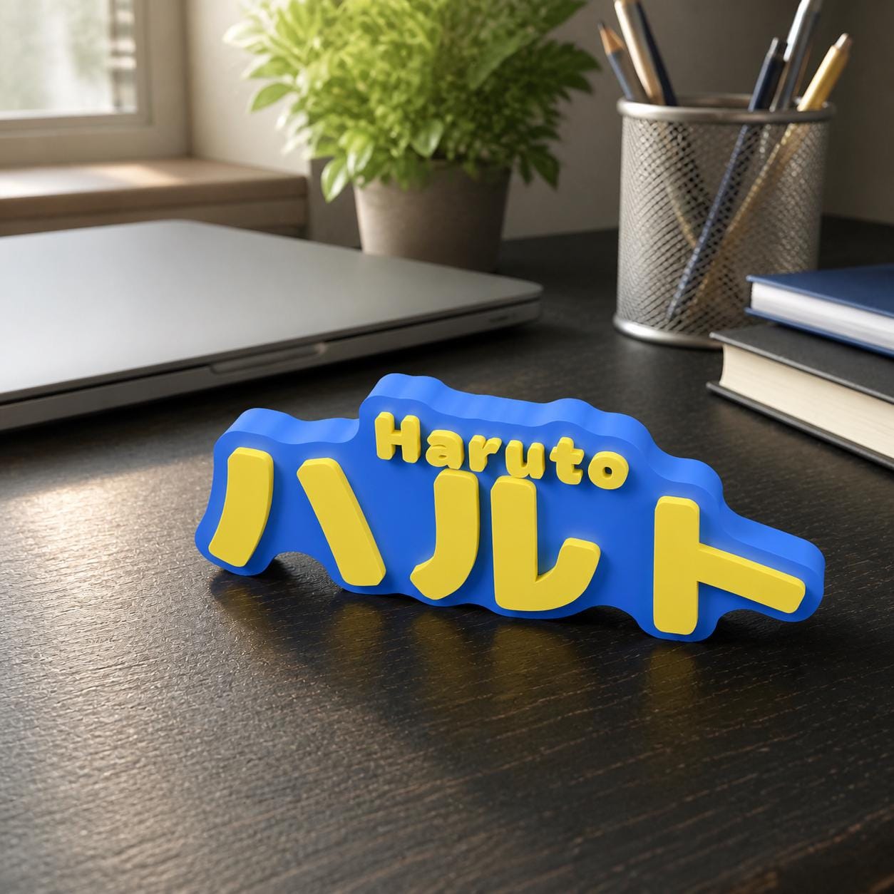 Virtual lifestyle scene of the cobalt blue and yellow Haruto and ハルト personalised nameplate standing on a dark home-study desk.
