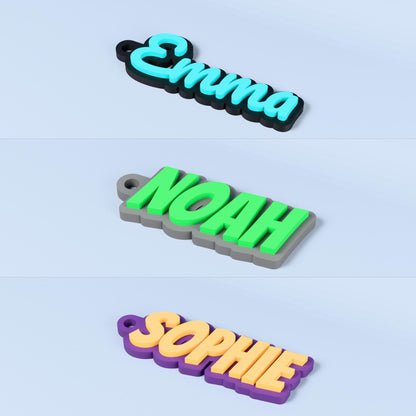 Three personalised 3D printed name keyrings showing Emma, Noah and Sophie in three two-colour combinations on a slate background.