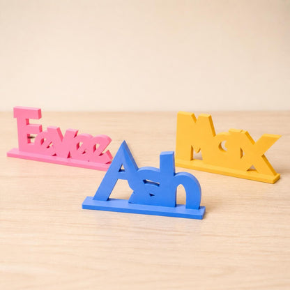 Eevee, Ash and Max creature adventure personalised PLA nameplates arranged in a warm neutral studio setting.
