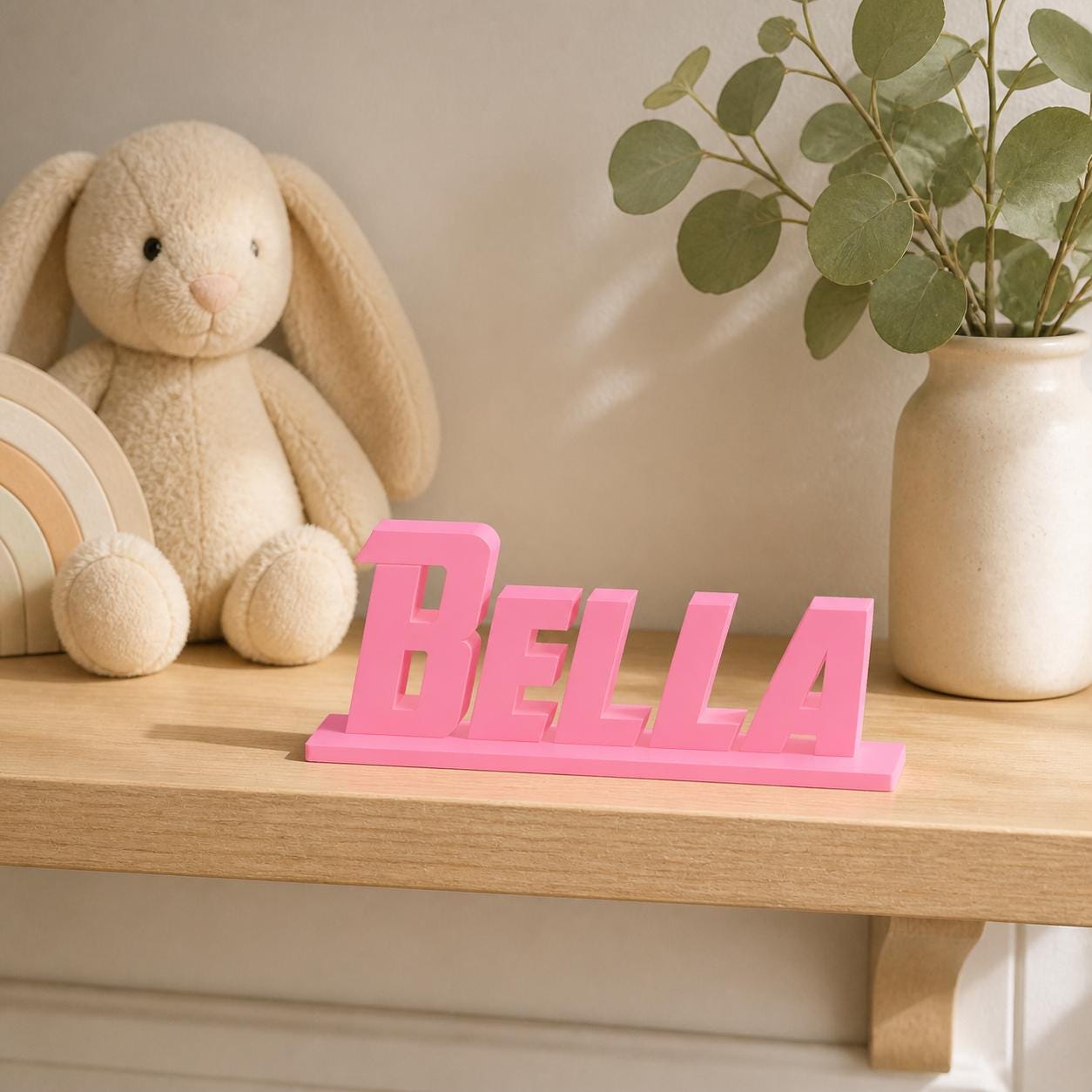 Bella heroic angular personalised nameplate displayed on a warm neutral nursery shelf.