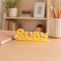Ruby cartoon style personalised nameplate displayed on a teacher's desk.