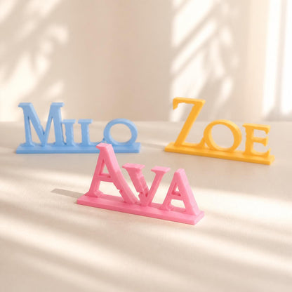 Ava, Milo and Zoe epic fantasy personalised PLA nameplates arranged in a warm neutral studio setting.