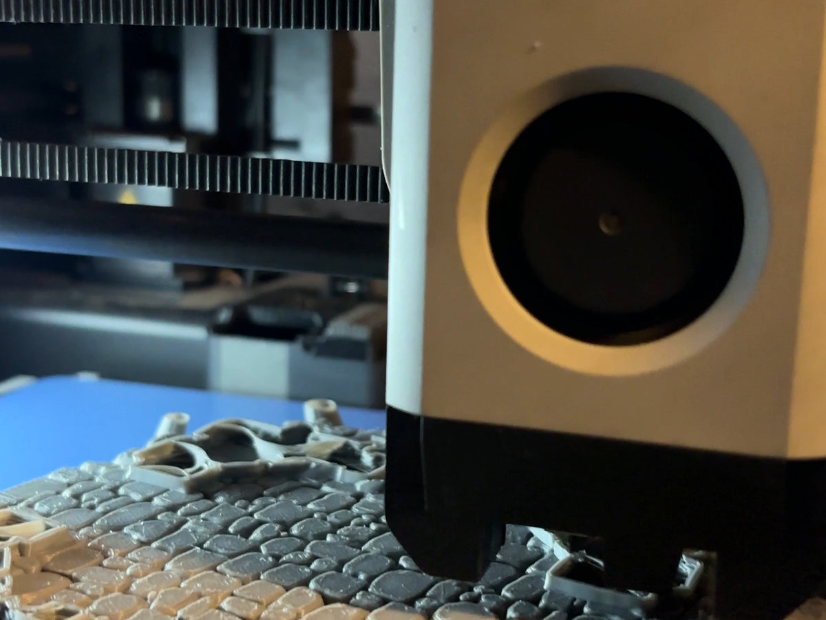 A Bambu Lab 3D printer part way through a plate of terrain tiles